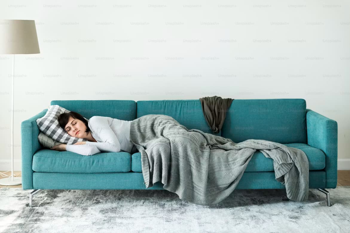 A person relaxing in a bright room cooled by a wall-mounted air-to-air unit
